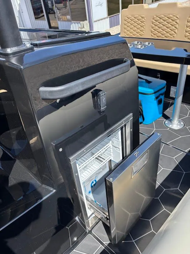 Slide: The Image of 2025 Highfield Sport 900 boat interior with open mini fridge and seating area. - 18