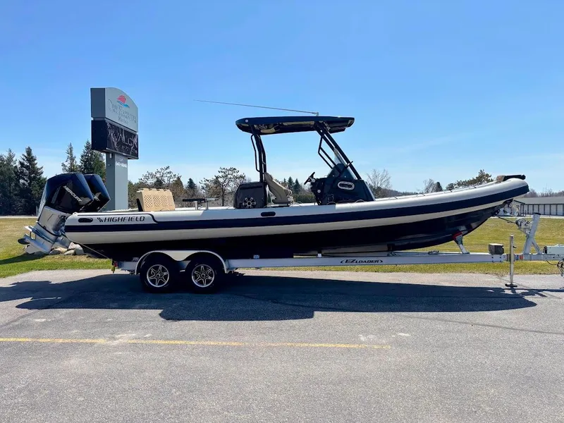Slide: The Image of 2025 Highfield Sport 900 boat on trailer, parked outdoors under clear blue sky. - 2