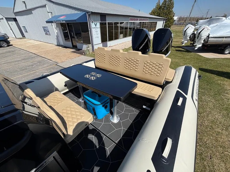 Slide: The Image of 2025 Highfield Sport 900 boat interior with seating, table, and twin engines, displayed outdoors. - 20