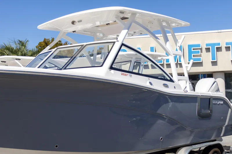Slide: The Image of 2025 Sea Fox 268 Traveler boat with sleek design, docked outdoors under clear blue sky. - 2