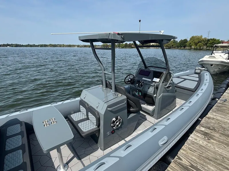 Slide: The Image of 2025 Highfield Sport 900 boat docked on a calm lake, featuring modern design and seating. - 2