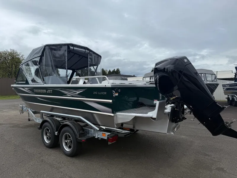 Slide: The Image of 2025 Thunder Jet 210 Luxor boat on trailer, featuring a sleek design and powerful outboard motor. - 4