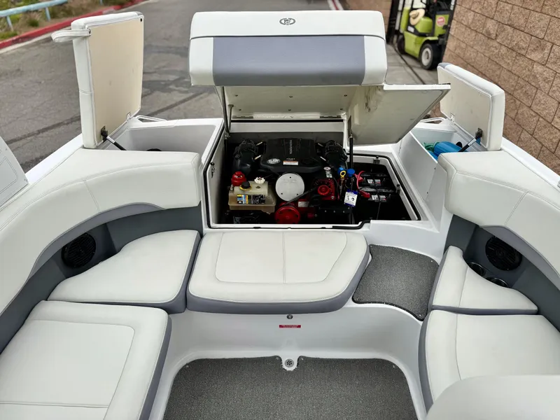 Slide: The Image of 2020 Cobalt 220S boat interior with open engine compartment, showcasing seating and storage. - 20