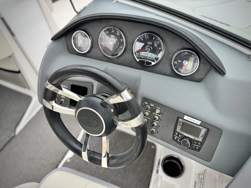 Slide: The Image of Steering wheel and dashboard of 2020 Cobalt 220S boat, featuring gauges and controls. - 28