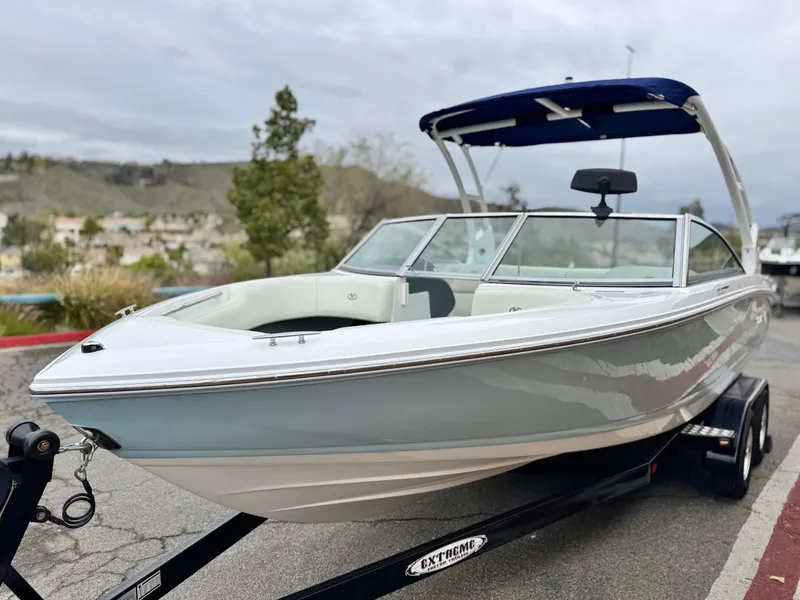 Slide: The Image of 2020 Cobalt 220S boat on trailer, sleek design, blue canopy, parked outdoors. - 3
