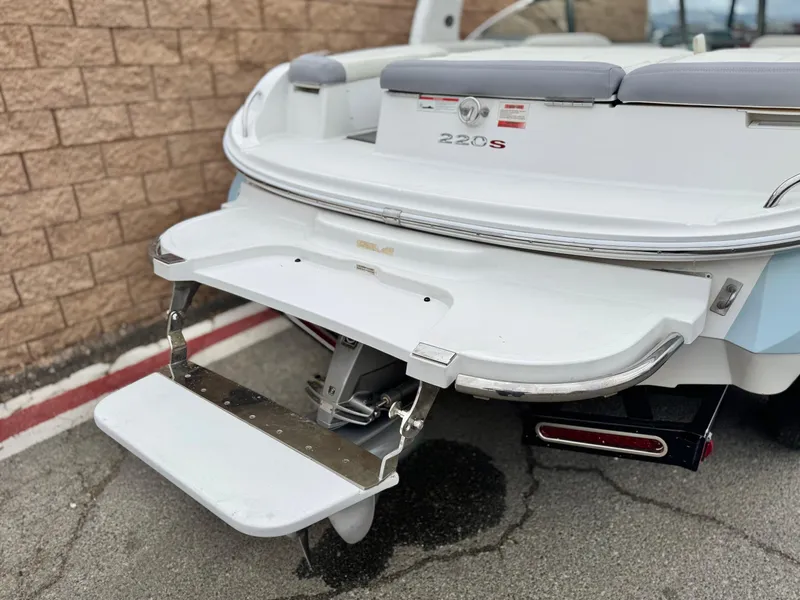 Slide: The Image of 2020 Cobalt 220S boat with swim platform, parked near a brick wall. - 7