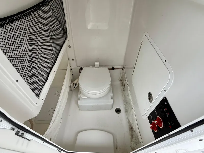 Slide: The Image of 2019 Sea Hunt Gamefish 25 boat interior with marine toilet and storage compartments. - 18