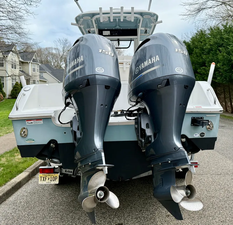 Slide: The Image of 2019 Sea Hunt Gamefish 25 with twin Yamaha 150 engines, parked on a residential street. - 29