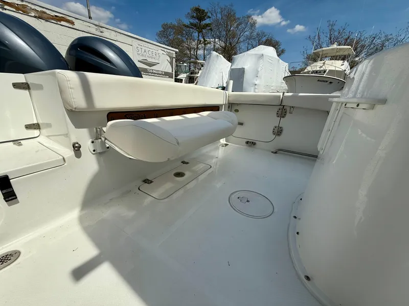 Slide: The Image of 2019 Sea Hunt Gamefish 25 boat interior with seating and storage, under a clear blue sky. - 38