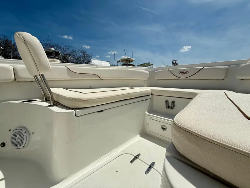 Slide: The Image of 2019 Sea Hunt Gamefish 25 boat interior with cushioned seating under a clear blue sky. - 42
