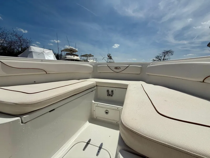 Slide: The Image of 2019 Sea Hunt Gamefish 25 boat interior with cushioned seating under a clear blue sky. - 43