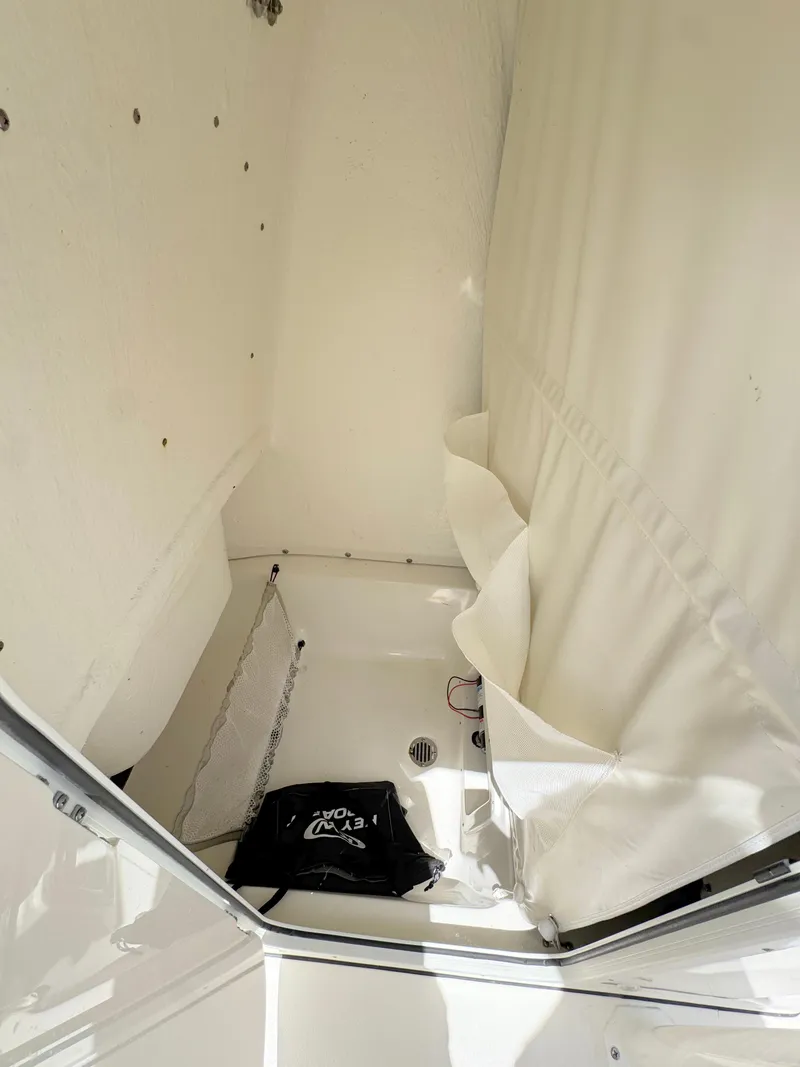 Slide: The Image of 2023 Key West 239 FS boat interior with white curtain and storage area. - 13