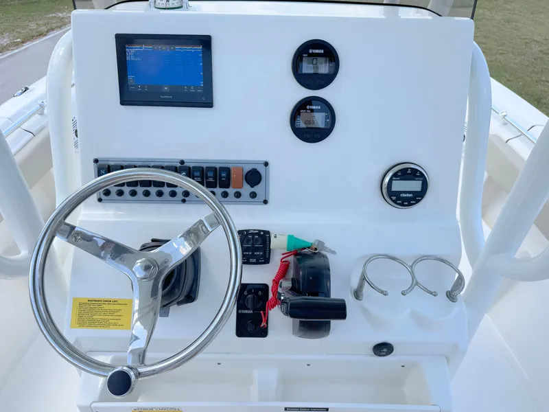 Slide: The Image of 2023 Key West 239 FS boat dashboard with steering wheel and navigation controls. - 17