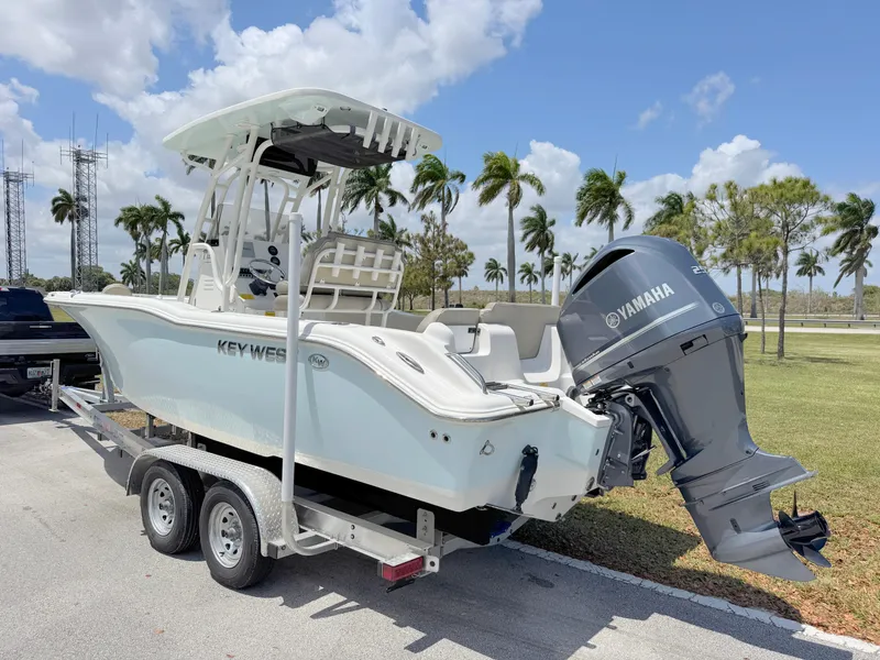 Slide: The Image of 2023 Key West 239 FS boat on trailer with Yamaha engine, parked outdoors. - 2