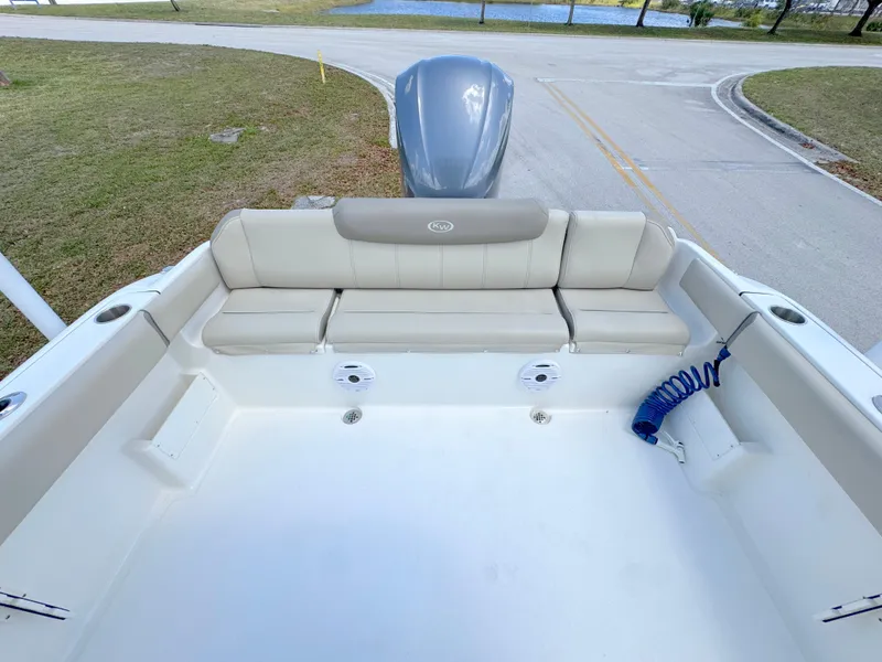 Slide: The Image of 2023 Key West 239 FS boat interior with cushioned seating and motor view. - 21