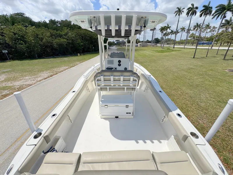 Slide: The Image of 2023 Key West 239 FS boat with spacious deck, center console, and seating, surrounded by palm trees. - 27