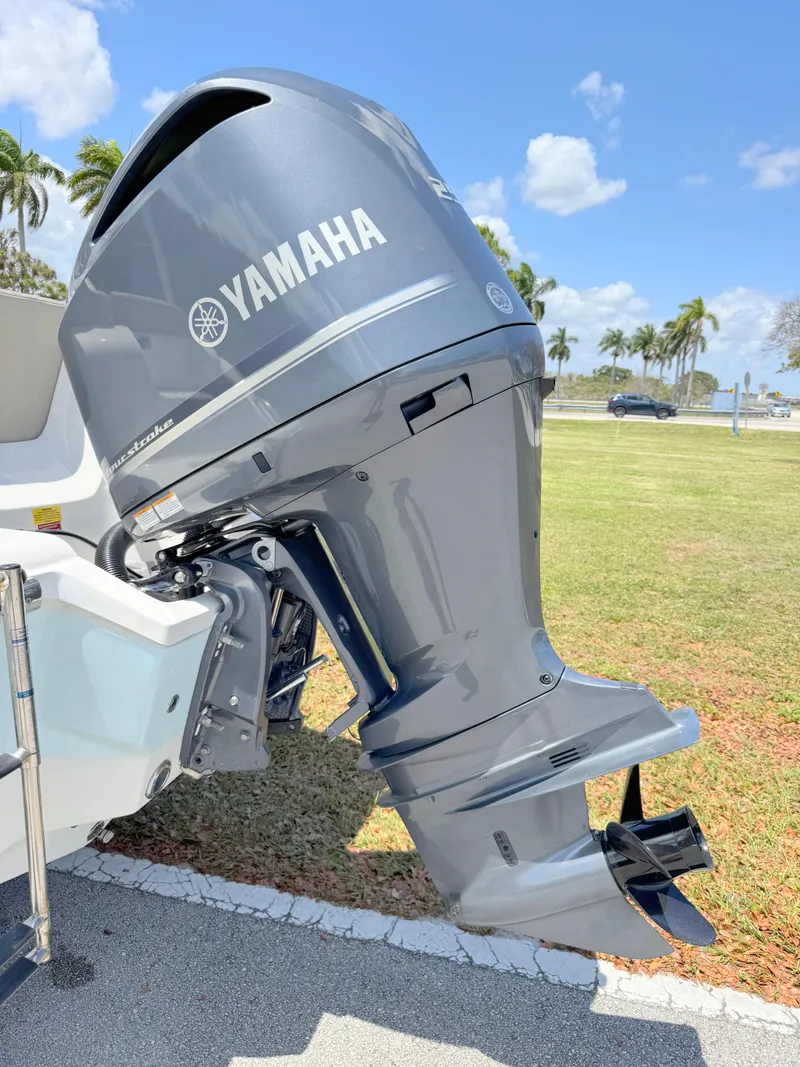 Slide: The Image of 2023 Key West 239 FS boat with Yamaha outboard motor, parked on grass under a clear sky. - 28
