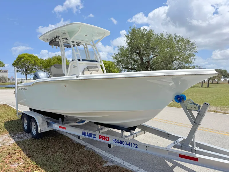 Slide: The Image of 2023 Key West 239 FS boat on trailer, parked outdoors under a blue sky. - 6