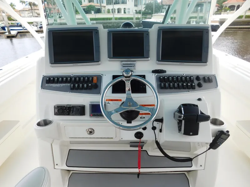 Slide: The Image of 2013 Hydra-Sports 4200 Siesta boat dashboard with multiple screens and controls. - 32