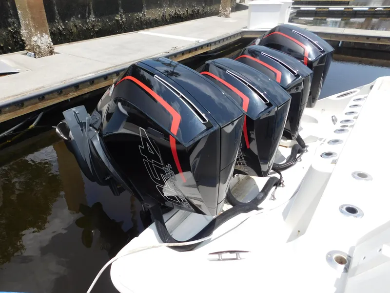 Slide: The Image of Four powerful outboard motors on a 2013 Hydra-Sports 4200 Siesta boat docked. - 6