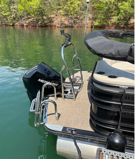 Slide: The Image of 2019 Harris Solstice 220 pontoon boat with Mercury engine on a calm lake. - 2