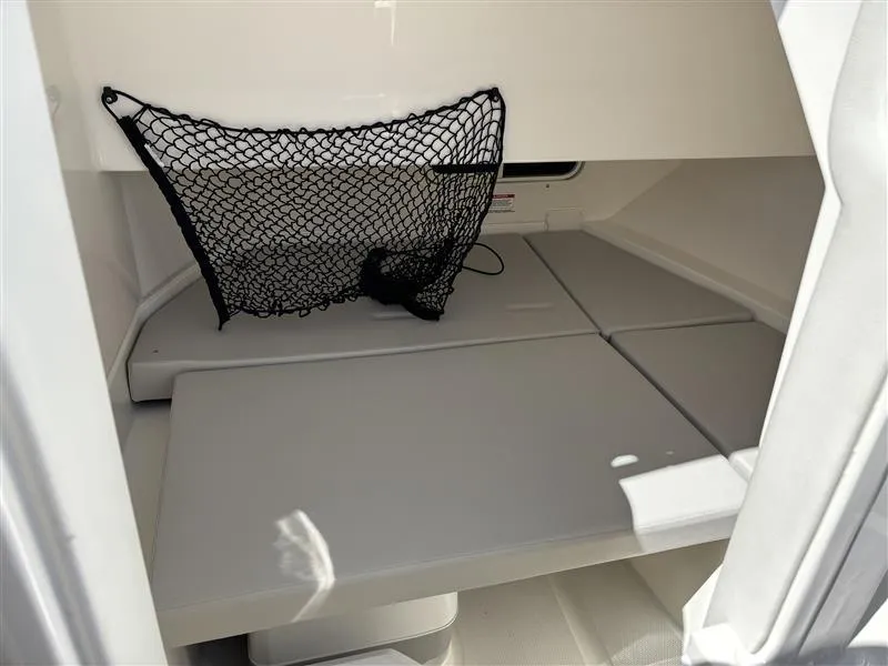 Slide: The Image of 2025 Sea Ray SDX 250 cabin interior with storage net and cushioned seating. - 6
