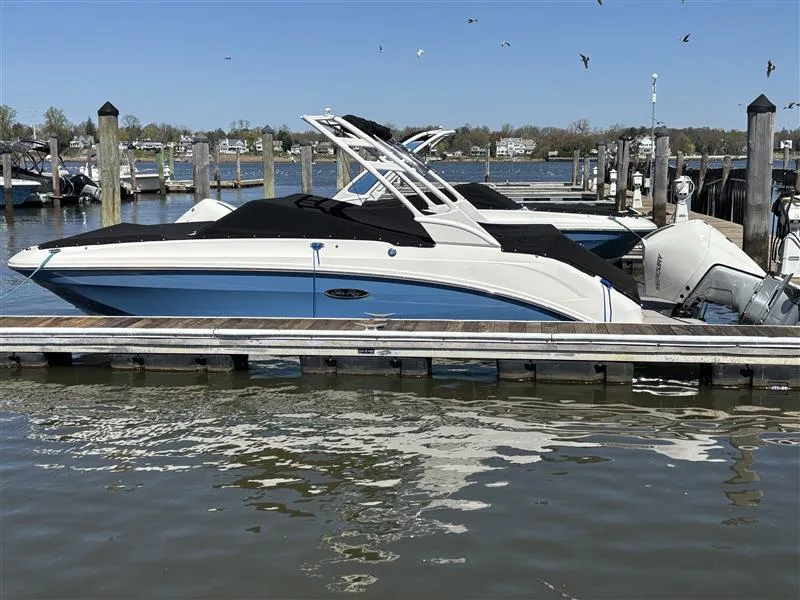 Slide: The Image of 2025 Sea Ray SDX 250 boat docked at marina, featuring sleek design and blue hull. - 8
