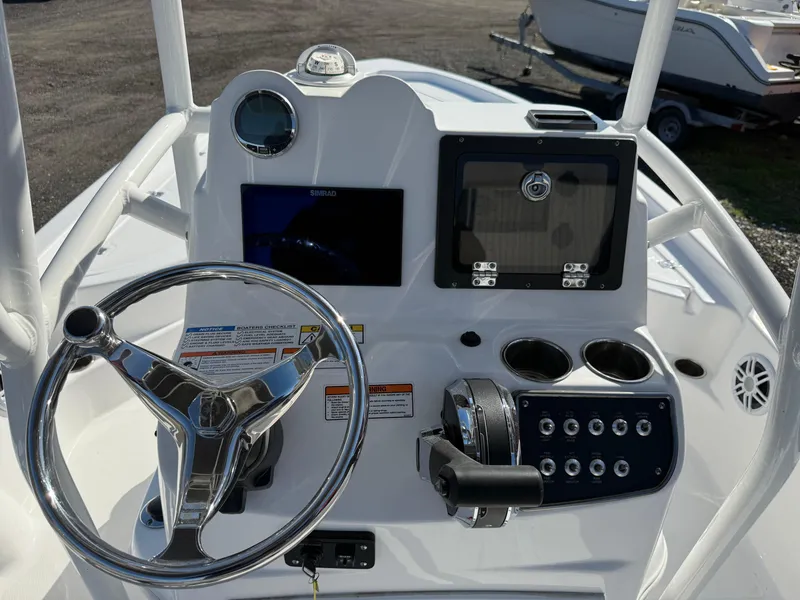 Slide: The Image of 2025 NauticStar 214 Shallow Bay boat console with steering wheel and control panel. - 13