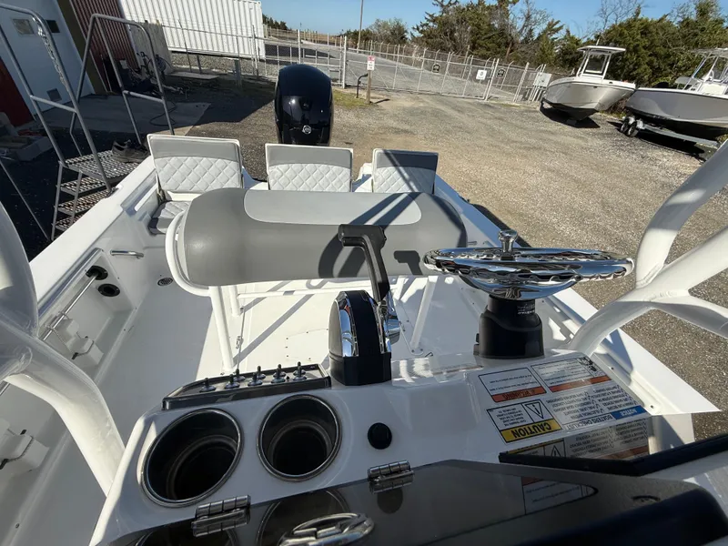 Slide: The Image of 2025 NauticStar 214 Shallow Bay boat interior with steering wheel and seating. - 17