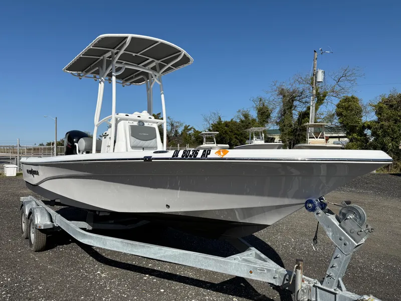 Slide: The Image of 2025 NauticStar 214 Shallow Bay boat on trailer, clear sky background. - 7