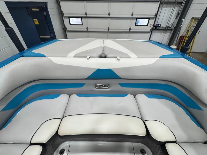 Slide: The Image of 2017 Malibu Wakesetter 23 LSV interior with blue and white seating in a garage. - 17