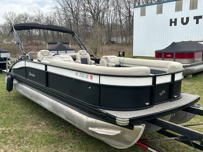 Slide: The Image of 2021 Barletta C24UC Triple Toon pontoon boat on grass near a building. - 1