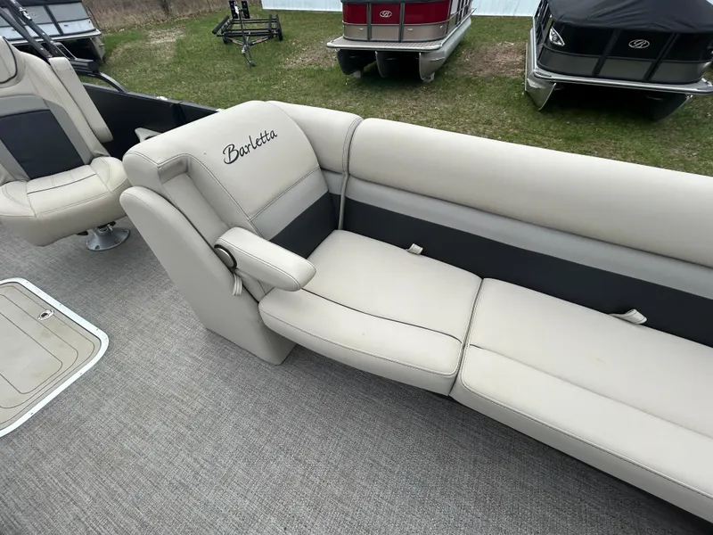 Slide: The Image of 2021 Barletta C24UC Triple Toon boat interior with beige seating and Barletta logo. - 16