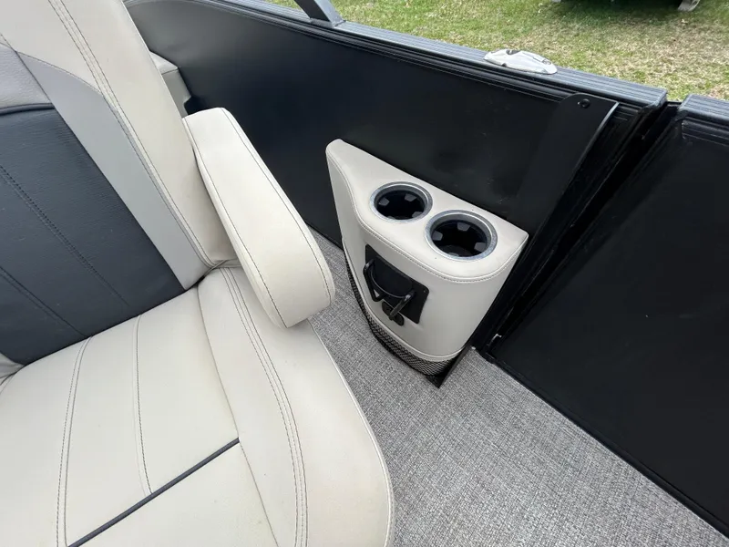 Slide: The Image of Interior of 2021 Barletta C24UC Triple Toon with beige seating and dual cup holders. - 18