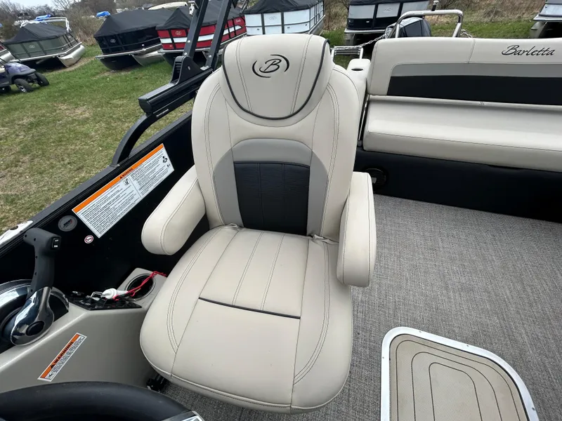 Slide: The Image of Captain's chair in 2021 Barletta C24UC Triple Toon pontoon boat, featuring beige upholstery. - 19