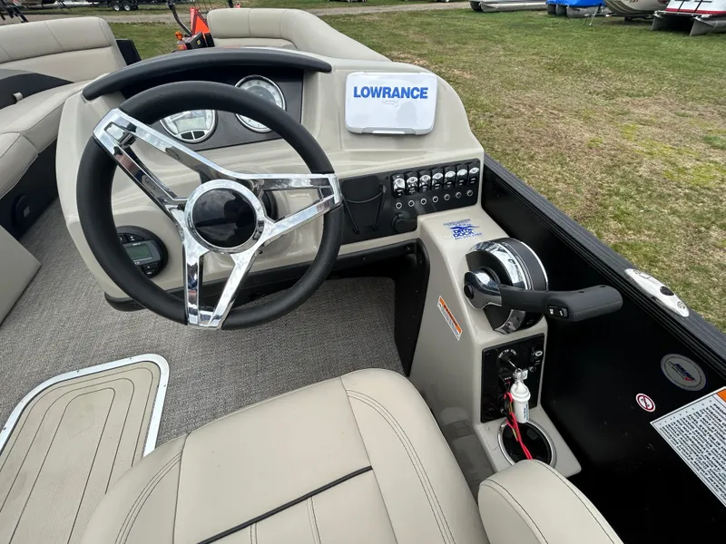 Slide: The Image of 2021 Barletta C24UC Triple Toon boat dashboard with steering wheel and controls. - 20
