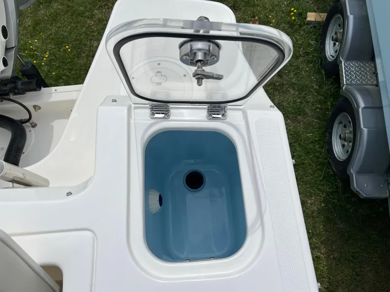 Slide: The Image of Open storage compartment on 2025 Boston Whaler 240 Vantage boat, featuring a blue interior. - 10