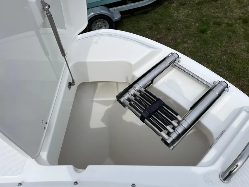 Slide: The Image of 2025 Boston Whaler 240 Vantage boat with a foldable ladder in storage compartment. - 13