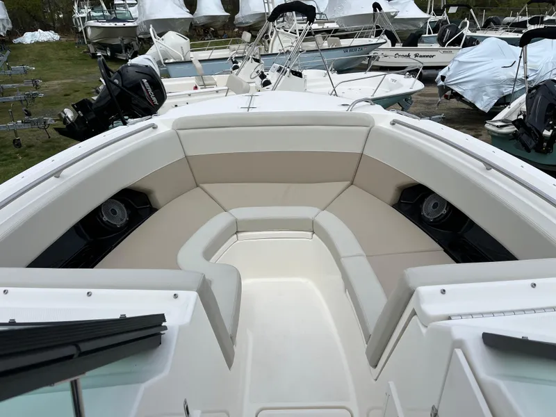 Slide: The Image of 2025 Boston Whaler 240 Vantage boat interior with cushioned seating and speakers. - 14
