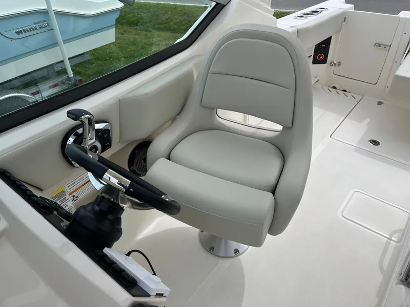 Slide: The Image of Captain's seat and helm of 2025 Boston Whaler 240 Vantage boat. - 19