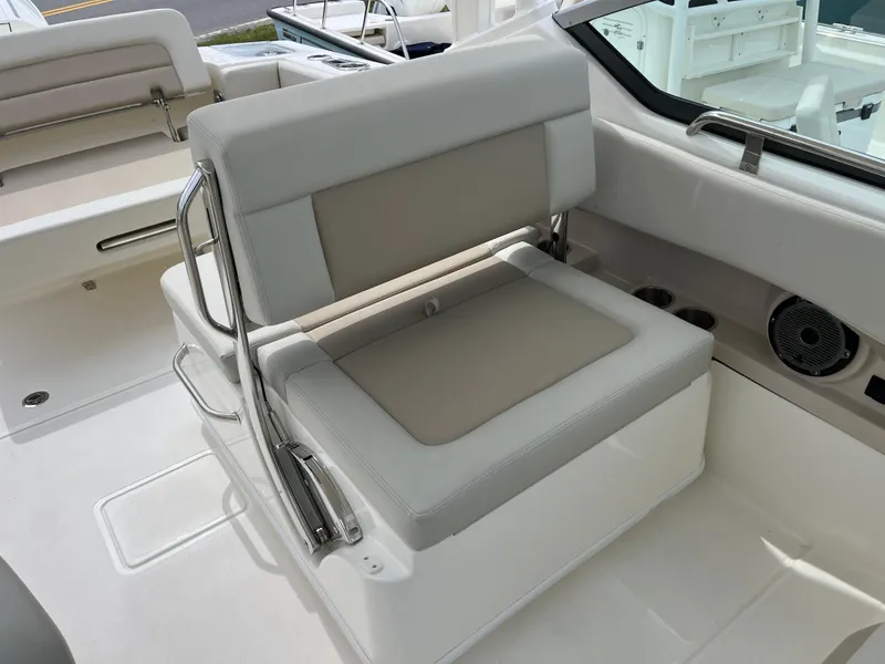 Slide: The Image of 2025 Boston Whaler 240 Vantage boat interior with cushioned seating and stainless steel accents. - 22