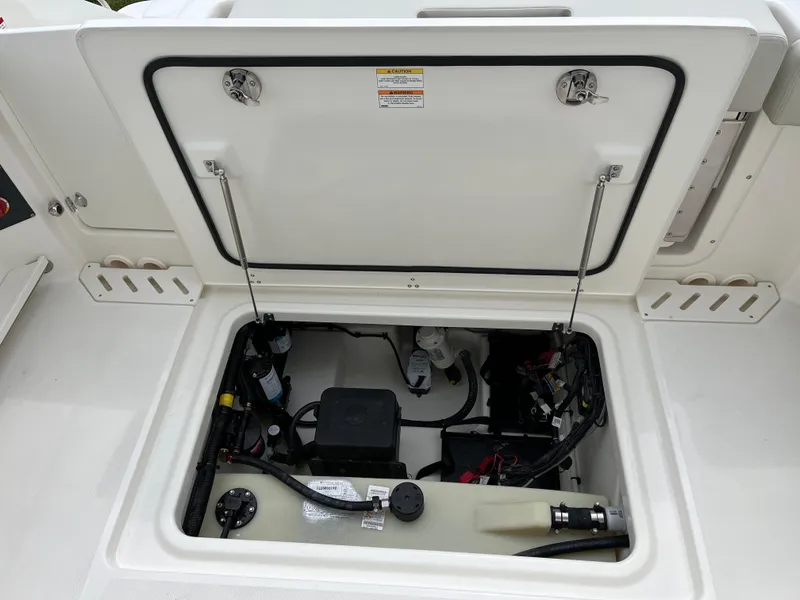 Slide: The Image of Open storage compartment of 2025 Boston Whaler 240 Vantage boat, showing internal components. - 28