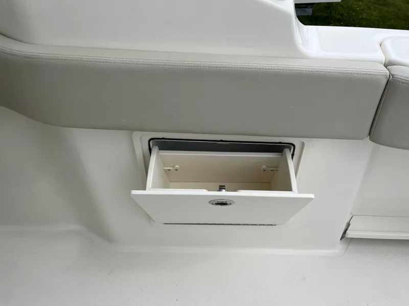 Slide: The Image of Storage compartment on 2025 Boston Whaler 240 Vantage boat, open with gray cushioned seating. - 29