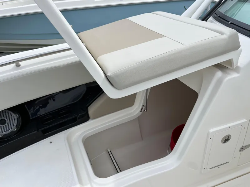Slide: The Image of 2025 Boston Whaler 240 Vantage boat storage compartment with cushioned seat. - 31