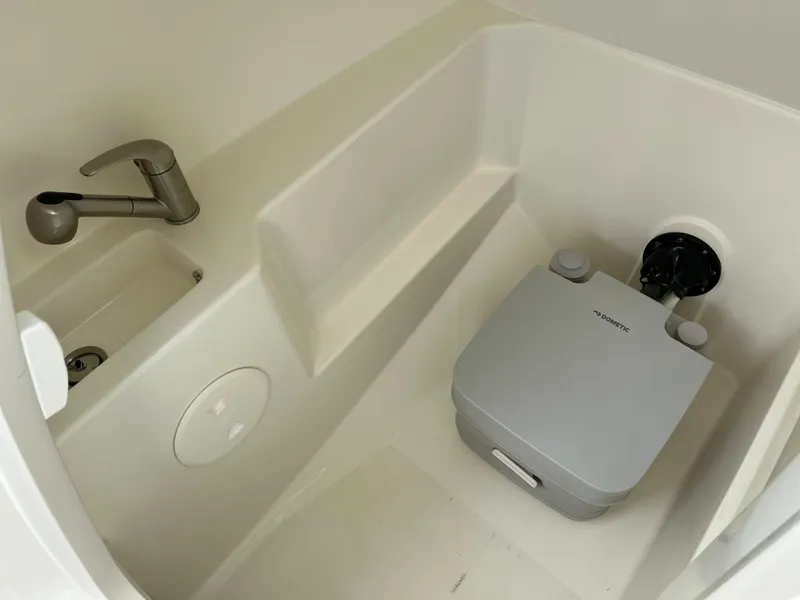 Slide: The Image of Interior of 2025 Boston Whaler 240 Vantage, featuring a compact sink and portable toilet. - 4