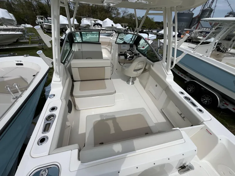 Slide: The Image of 2025 Boston Whaler 240 Vantage boat interior with seating and helm, displayed outdoors. - 5