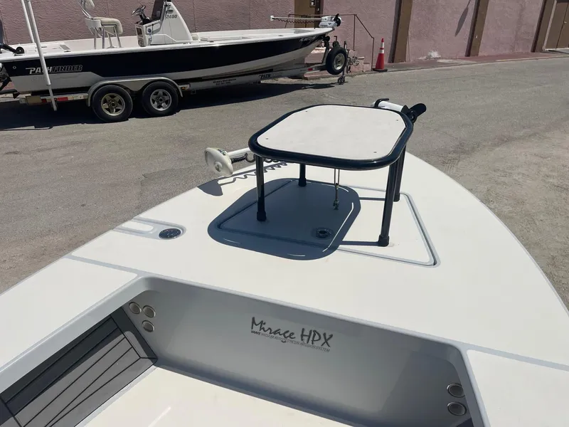 Slide: The Image of 2019 Maverick Mirage 18 HPX-V boat with elevated platform, parked near another boat. - 11