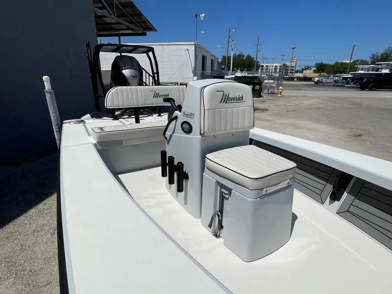 Slide: The Image of 2019 Maverick Mirage 18 HPX-V boat interior with seating and storage, parked outdoors. - 6