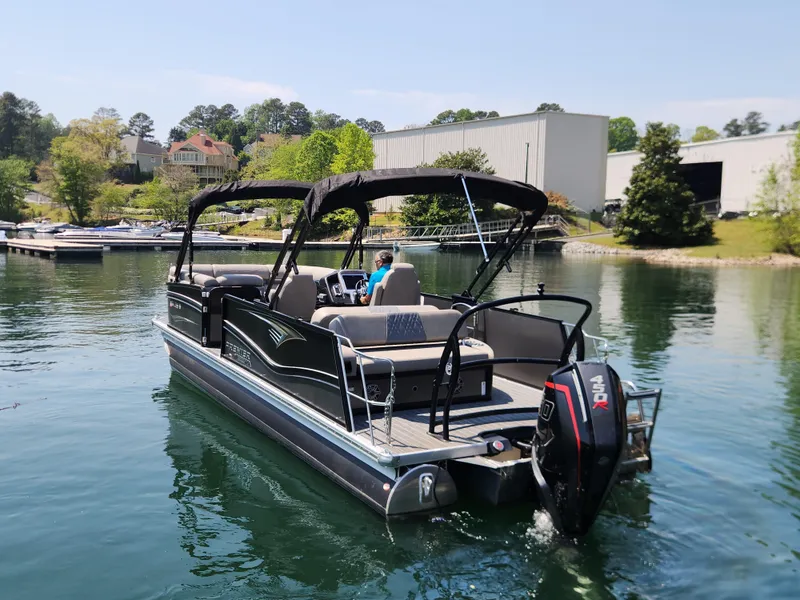 Slide: The Image of 2023 Premier 250 Intrigue RL pontoon boat on a serene lake. - 0
