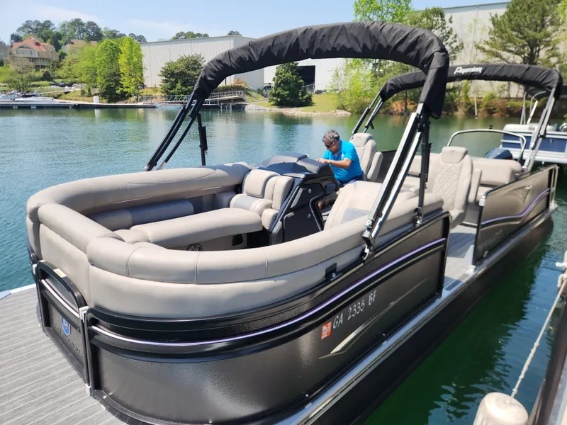 Slide: The Image of 2023 Premier 250 Intrigue RL pontoon boat docked on a sunny lake. - 10
